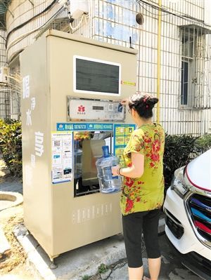 5月24日，瓊山區(qū)上丹花苑小區(qū)居民陳女士在使用共享凈水機(jī)取水。 本報記者 陳歆卓 攝